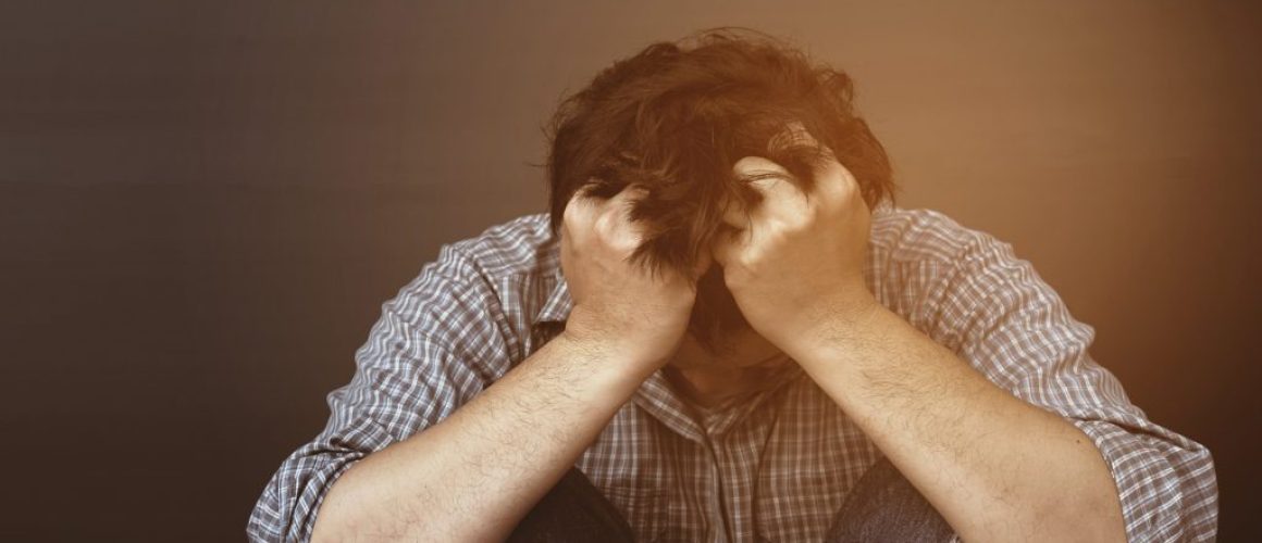 Sad man holding head with hand