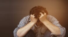 Sad man holding head with hand